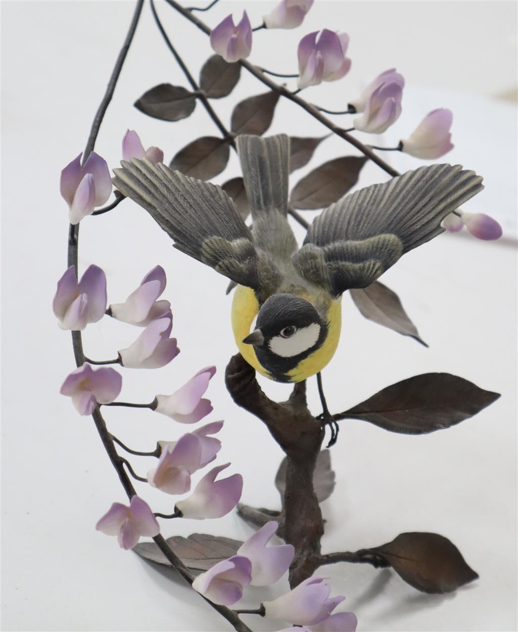 A Boehm model Thrush on a branch with yellow wisteria, and a Coal Tit Thrush on a branch surrounded by lilac wisteria, tallest 29cm